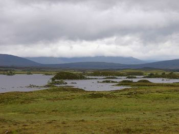 Scenic view of field and mountains against sky