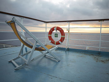 Close-up of information sign by sea against sky