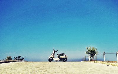 Cars on road against clear blue sky