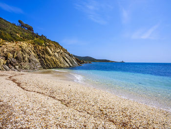 Scenic view of beach against blue sky