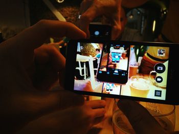 Close-up of man using mobile phone in restaurant