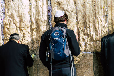 Rear view of people standing against trees