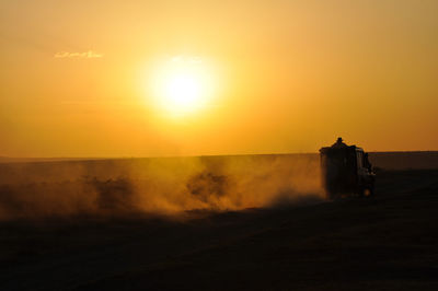 Scenic view of silhouette field against clear sky during sunset