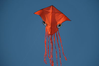 Low angle view of kite against clear blue sky