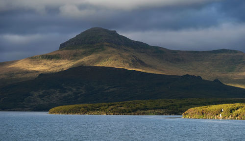 Scenic view of lake by mountains against sky