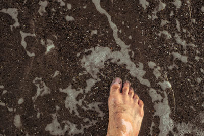 Close-up of barefoot in water