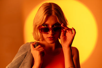 Portrait of young woman wearing sunglasses at home
