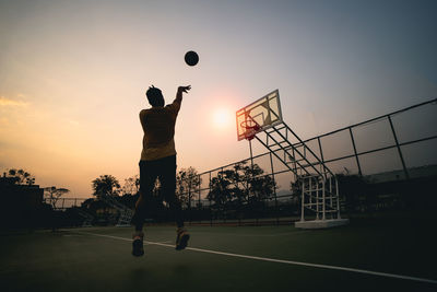 Low angle view of man playing basketball on field