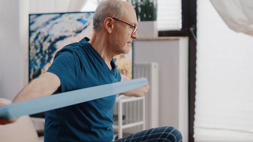 Side view of young man working at home