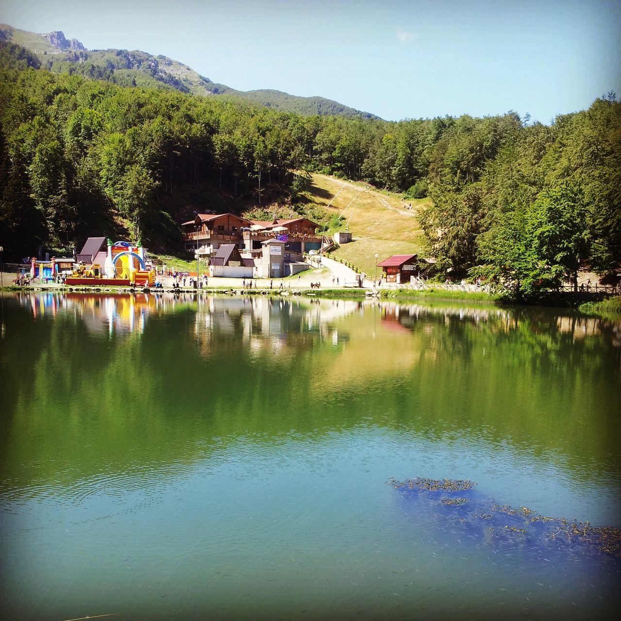 water, tree, building exterior, architecture, built structure, house, lake, reflection, waterfront, tranquil scene, mountain, tranquility, nature, growth, river, scenics, beauty in nature, green color, sky, residential structure