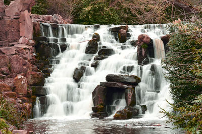 Waterfall cascading over natural rock formation 