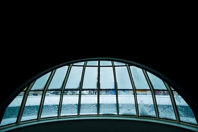 Low angle view of glass window against clear sky