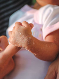 Close-up of baby holding person finger