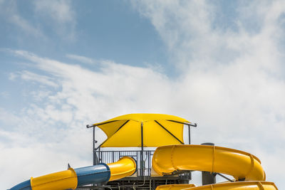 Low angle view of yellow crane against sky