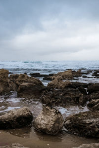 Rocks on beach against sky