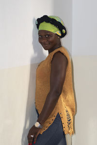 Portrait of woman standing against wall at home