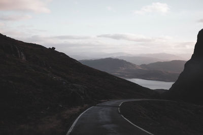 Road leading towards mountains against sky