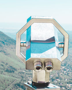 Close-up of coin-operated binoculars by sea against clear sky