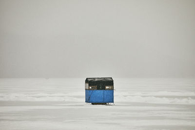 Ice fishing shanty on frozen lake in snow storm