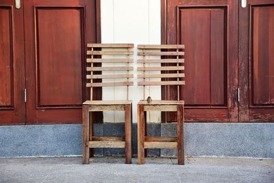 Empty chairs and tables against building