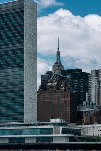 Buildings in city against cloudy sky