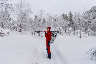 Teenage girl on snowshoe hike in a snowy forest in lapland