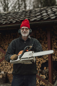Senior man holding chainsaw