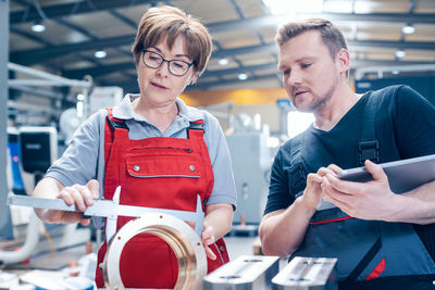 Young man working and woman using phone