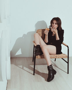 Young woman sitting on chair at home