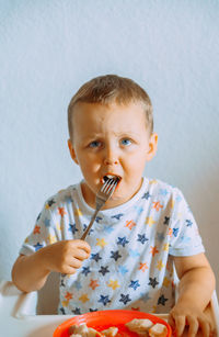 Portrait of cute boy eating food at home