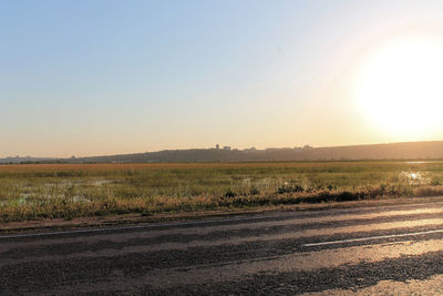 Scenic view of field against clear sky during sunset