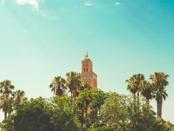 Low angle view of trees and building against sky