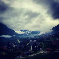 Houses in town against cloudy sky