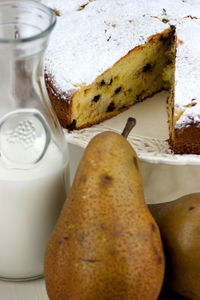 Close-up of chocolate cake with milk and pears on table