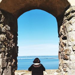 Rear view of woman looking at sea against sky