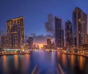 Illuminated buildings in city against sky at night