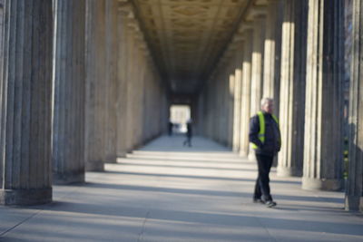 Rear view of man walking in corridor of building