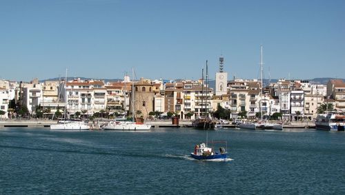 Buildings at waterfront against blue sky