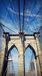 Low angle view of suspension bridge against blue sky