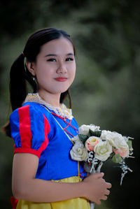 Portrait of young woman holding bouquet