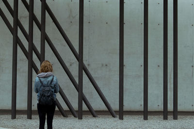 Rear view of woman standing on railing