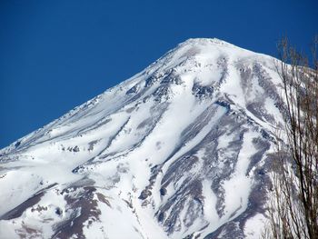 Scenic view of snowcapped mountains against blue sky