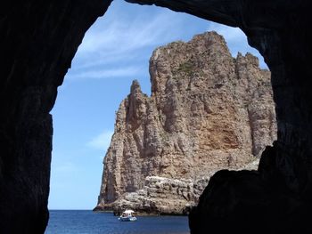 Rock formations in sea against sky