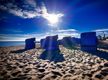 Scenic view of beach against blue sky on sunny day
