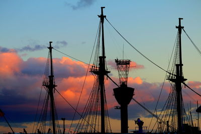 Low angle view of silhouette cranes against sky during sunset