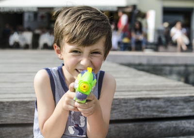 Portrait of smiling boy holding squirt gun