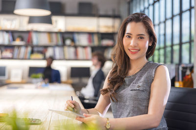 Modern businesswoman at the office, smiling female boss posing for a company photograph