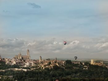 Buildings in city against cloudy sky