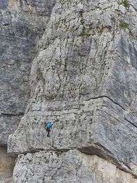Low angle view of man climbing huge rock