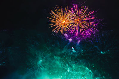 Low angle view of firework display at night